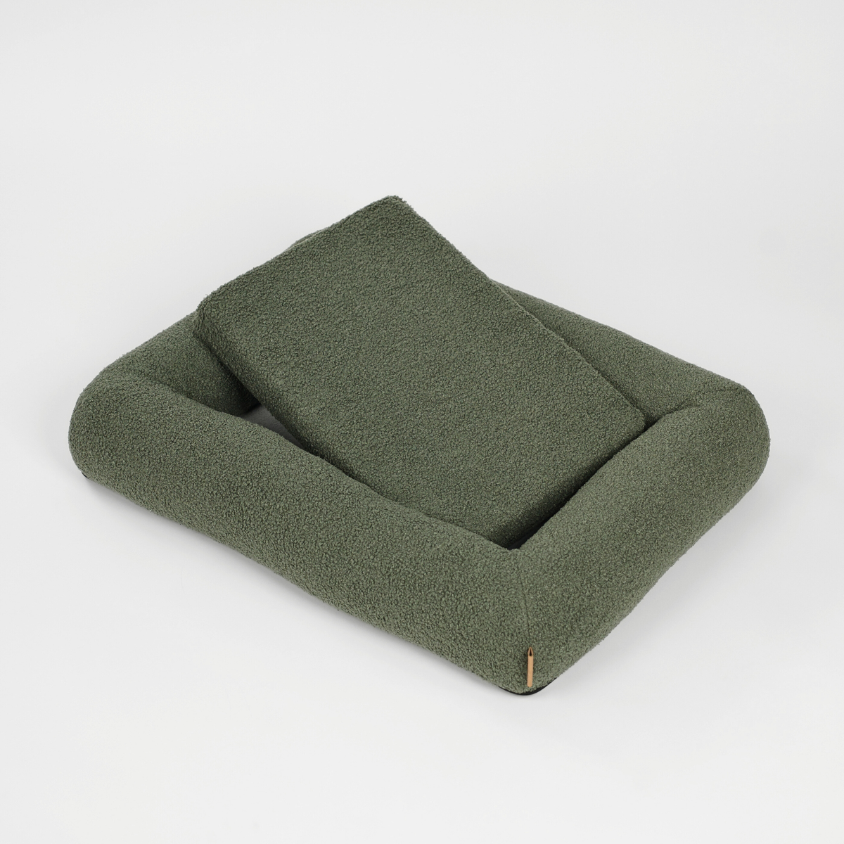 Moss green bouclé koiranpeti, jonka tyyny on nostettu pystyyn