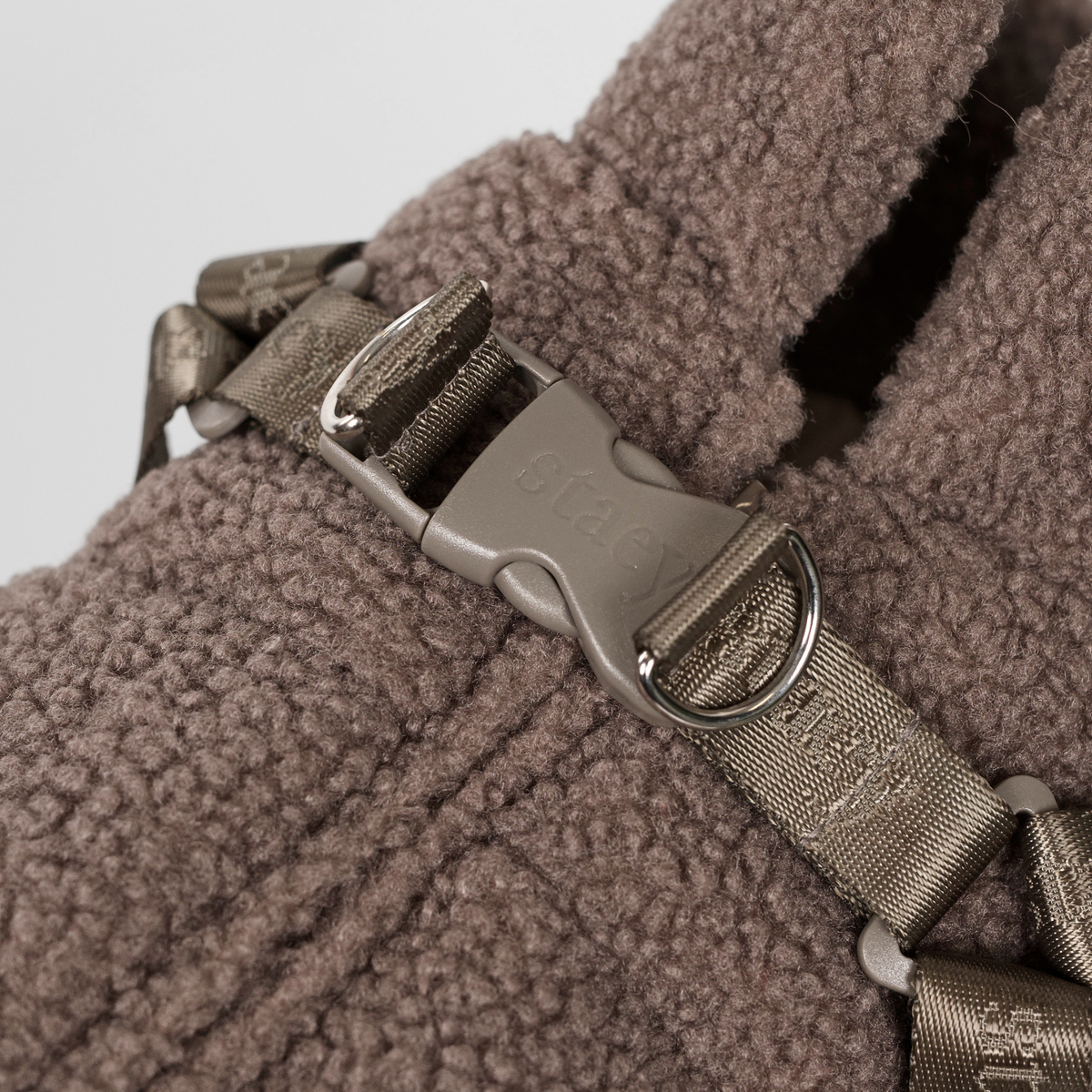 Close-up of the harness buckle on the taupe teddy dog coat