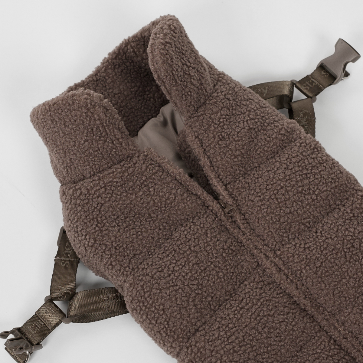 The taupe teddy dog coat with harness laid flat