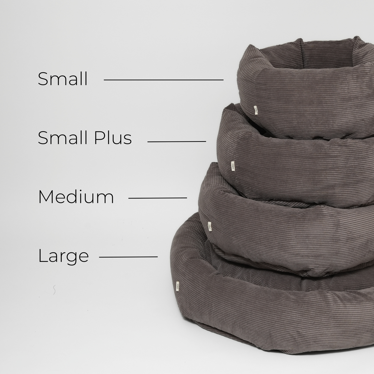 Kokoopas, jossa on esitetty taupe-värinen korduroy-koiranpeti koossa Small, Small Plus, Medium ja Large päällekkäin