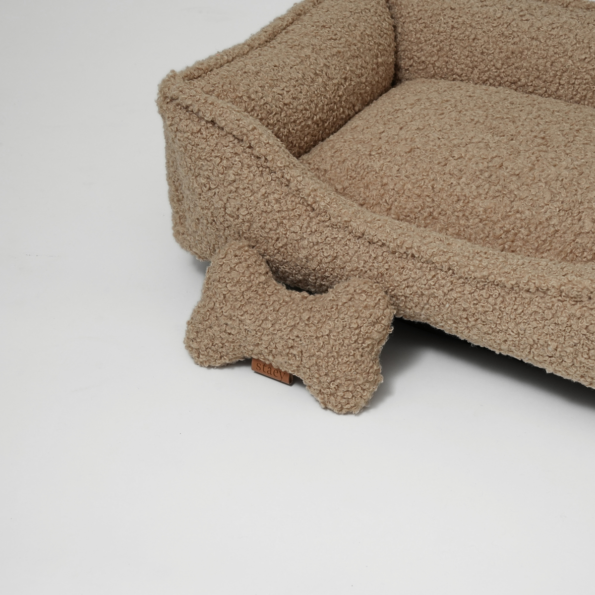 The sand curly bouclé dog bed with a matching bone-shaped cushion